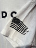 White shirt with black American flag design and 'DC' letters on a white background